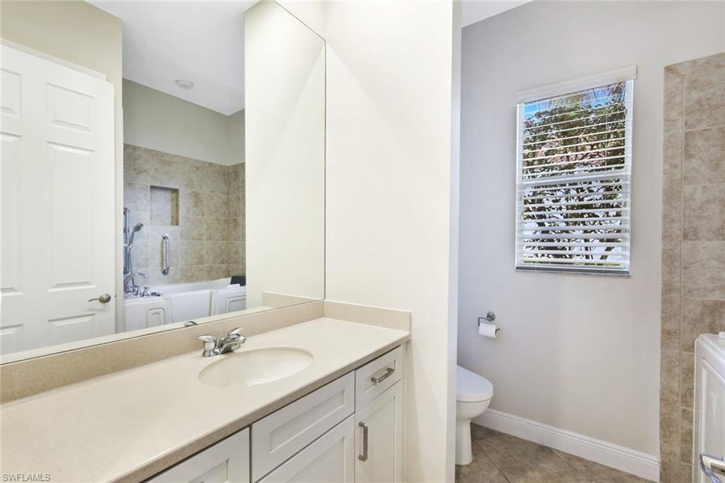 Bathroom with vanity, a tub, light tile patterned floors, and a shower