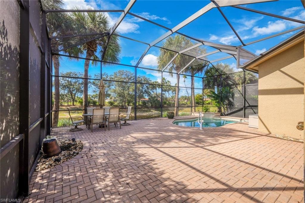 View of pool with a sunroom, a patio area, a lanai, and a pool with connected hot tub