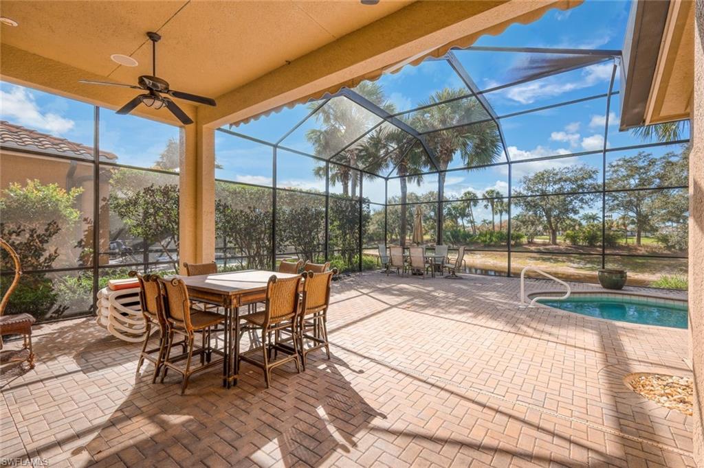 View of patio / terrace with a lanai, a sunroom, outdoor dining space, an outdoor pool, and ceiling fan