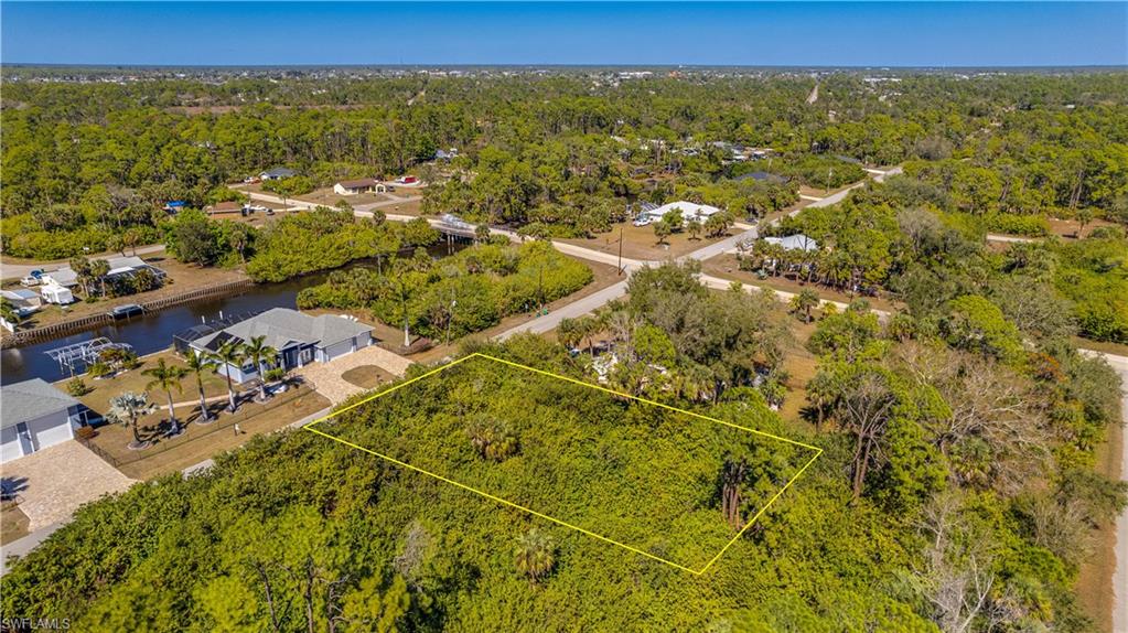 Aerial view of residential area featuring property parcel outlined and a nearby body of water