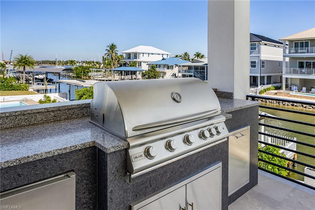 View of patio with an outdoor kitchen and a residential view - Virtually Edited Image