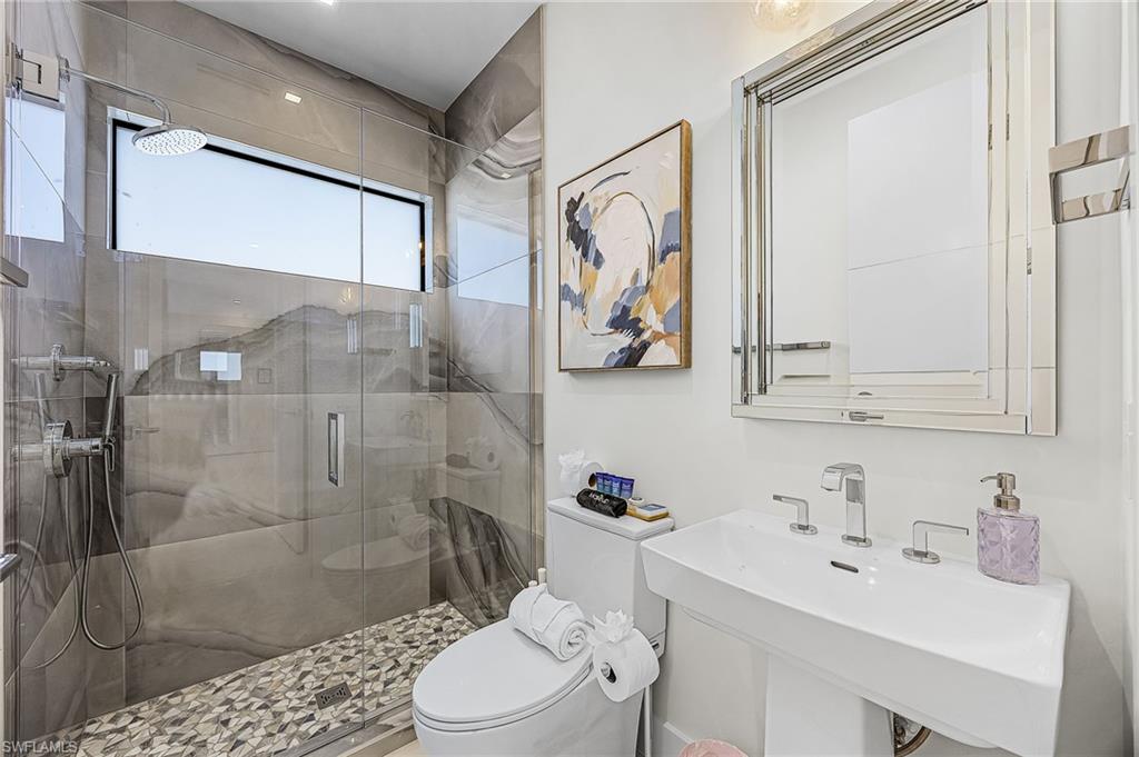 Full bath featuring a stall shower and toilet - Virtually Edited Image