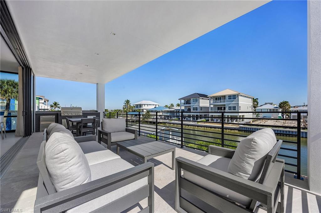 View of patio / terrace with an outdoor living space, outdoor dining space, a water view, and a grill