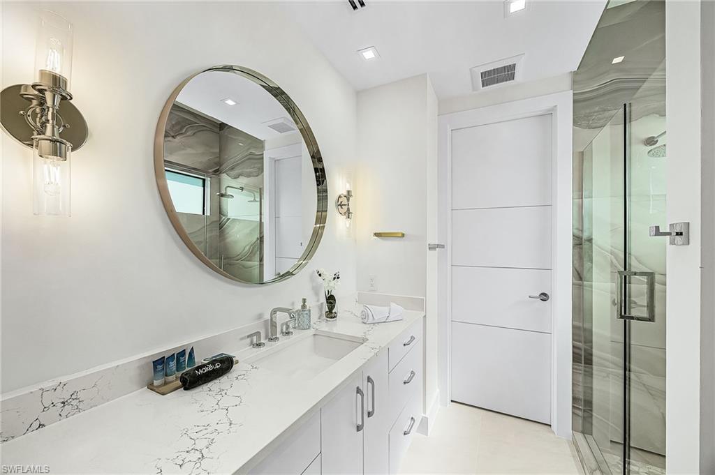 Bathroom featuring vanity and a marble finish shower - Virtually Edited Image