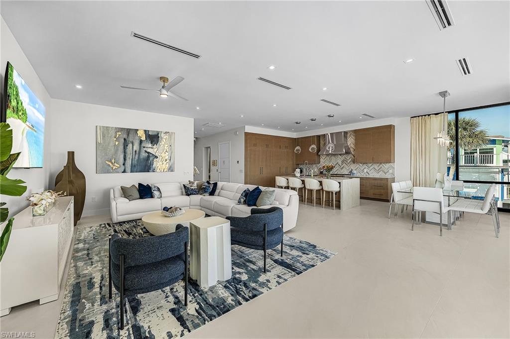 Living room with healthy amount of natural light, recessed lighting, and ceiling fan - Virtually Edited Image