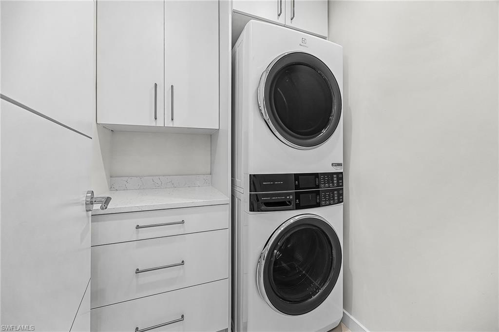 Laundry room with cabinet space and stacked washer and clothes dryer - Virtually Edited Image