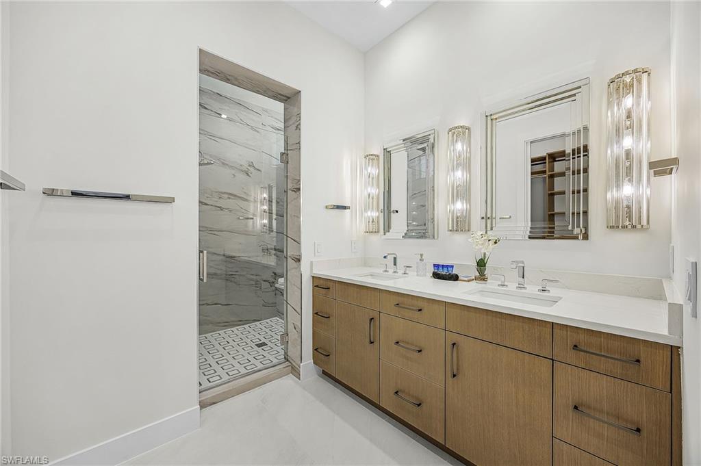 Bathroom featuring double vanity and a marble finish shower - Virtually Edited Image
