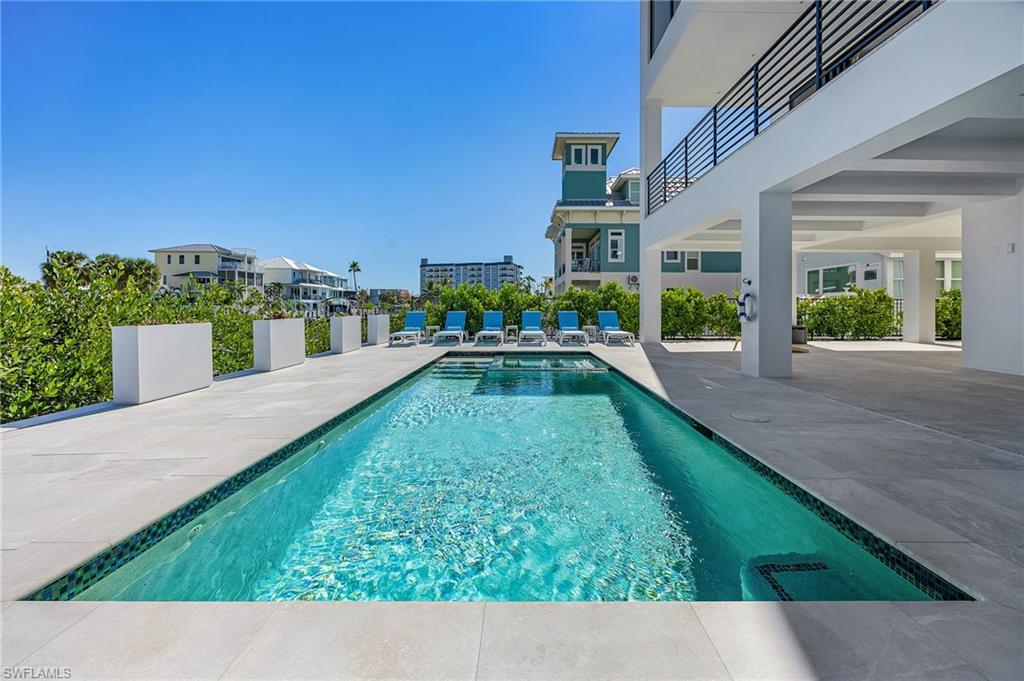 View of swimming pool with a patio area and a balcony - Virtually Edited Image