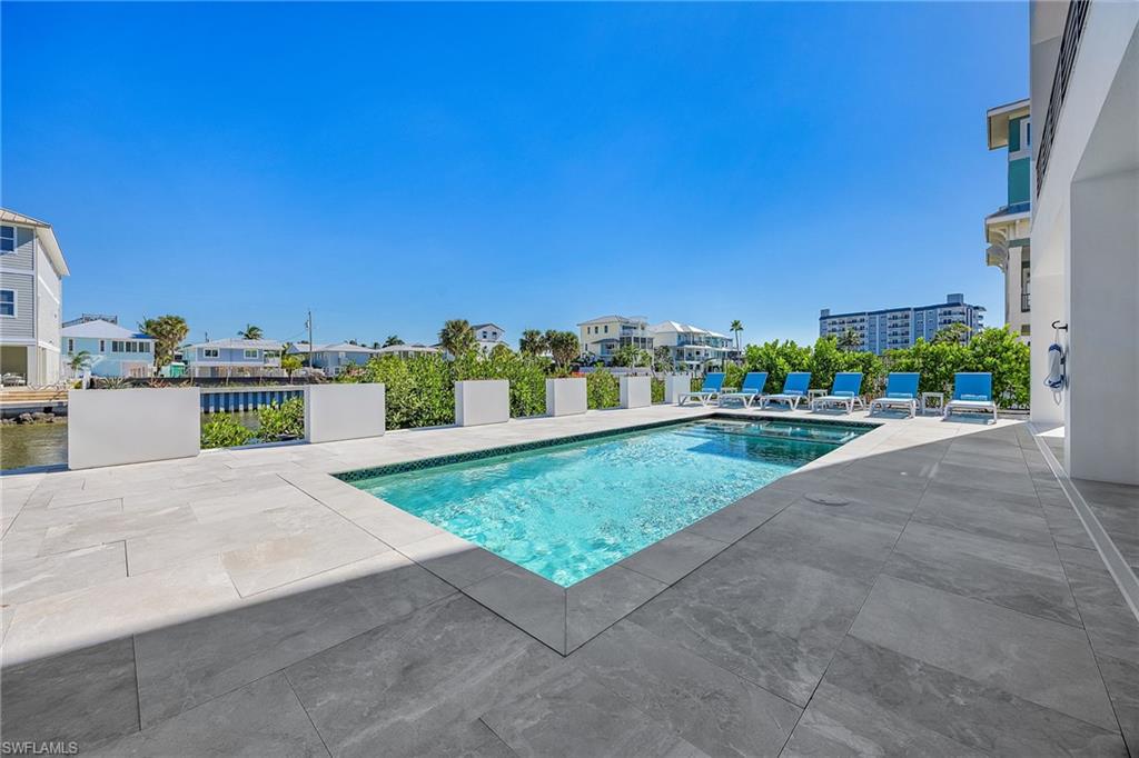 Outdoor pool with a patio area and a residential view - Virtually Edited Image