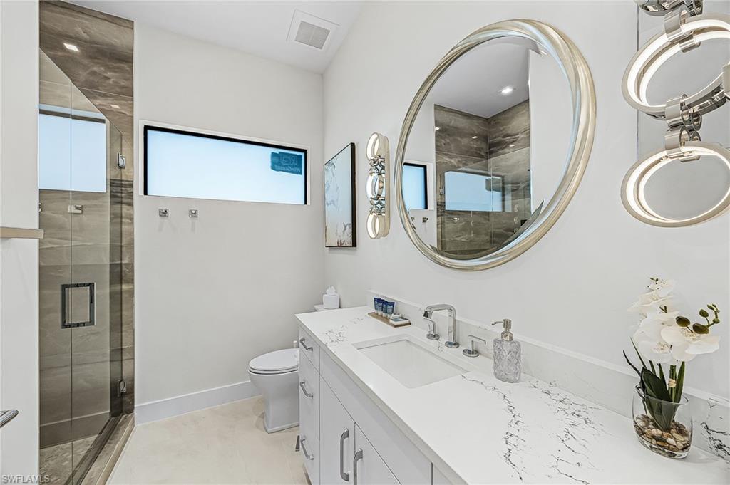 Full bath featuring vanity, a shower stall, and light tile patterned floors - Virtually Edited Image