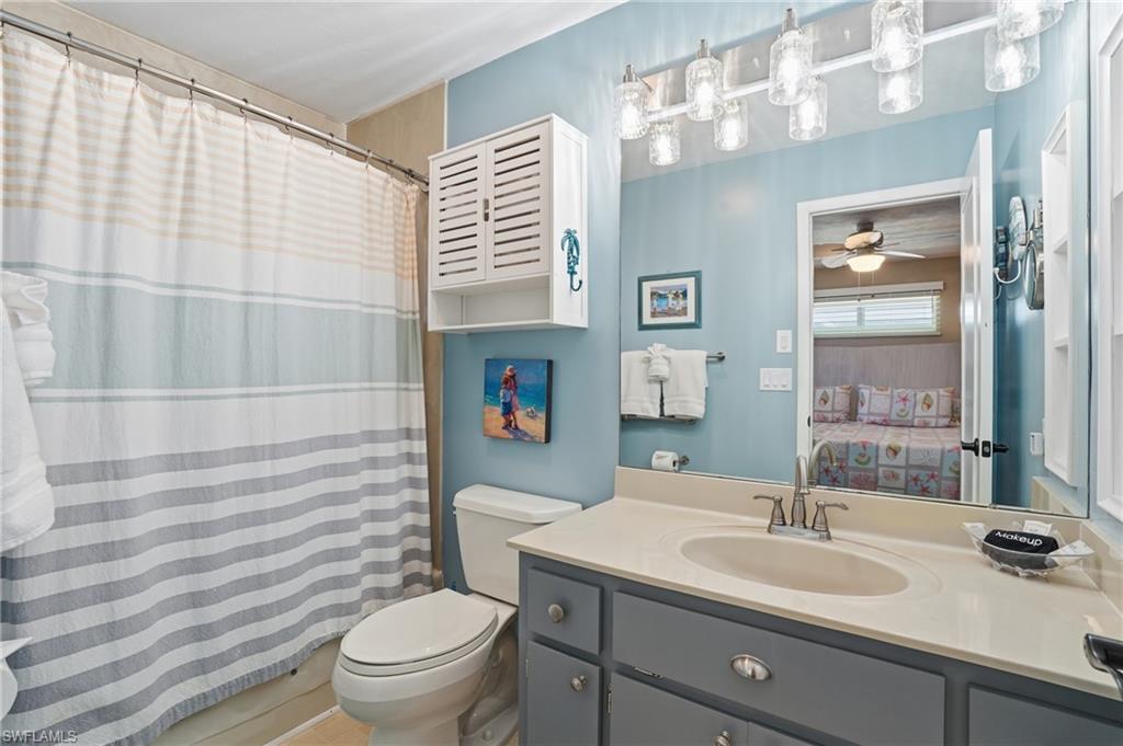 Bathroom with a shower with curtain, vanity, and connected bathroom - Virtually Edited Image