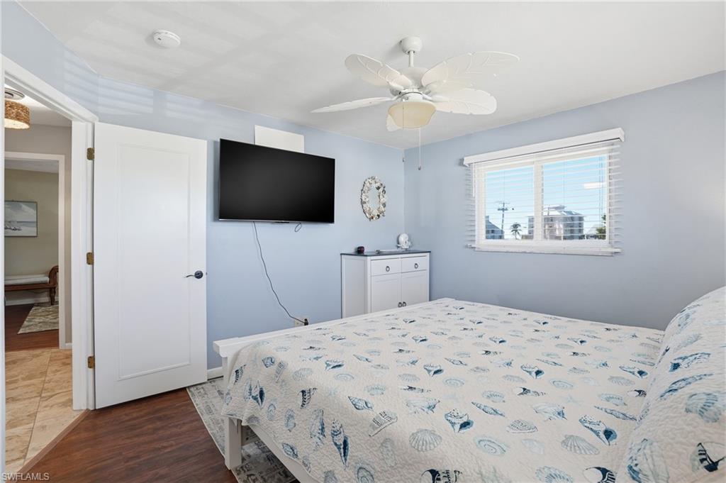 Bedroom with dark wood-type flooring and ceiling fan - Virtually Edited Image