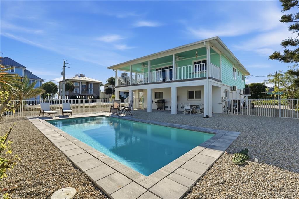 Rear view of property with a patio, a fenced backyard, and a ceiling fan - Virtually Edited Image