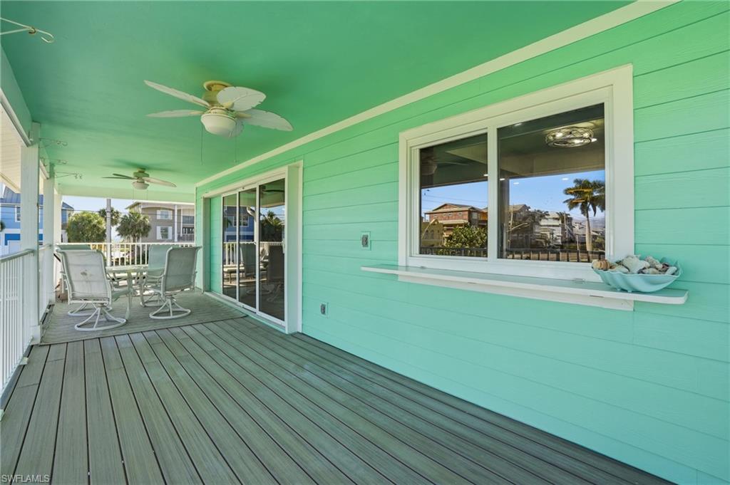 Wooden terrace with outdoor dining space and ceiling fan - Virtually Edited Image