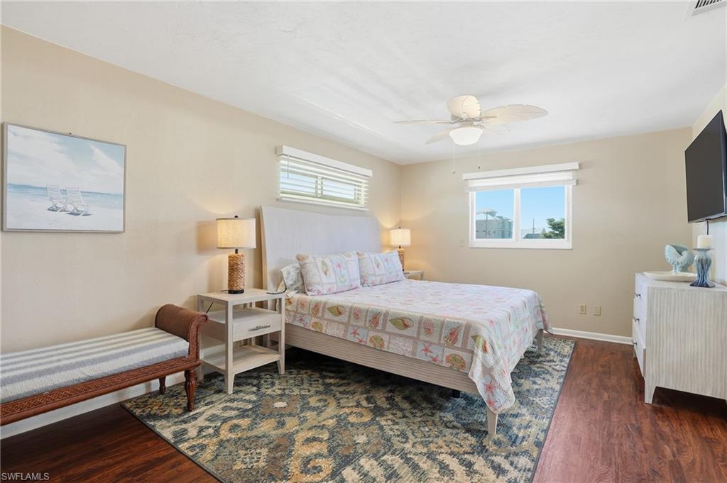 Bedroom featuring dark wood finished floors and a ceiling fan - Virtually Edited Image
