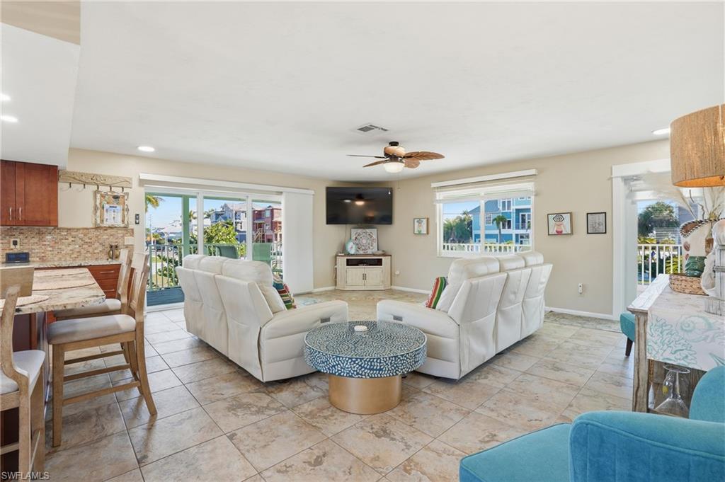 Living area featuring recessed lighting, healthy amount of natural light, and a ceiling fan - Virtually Edited Image