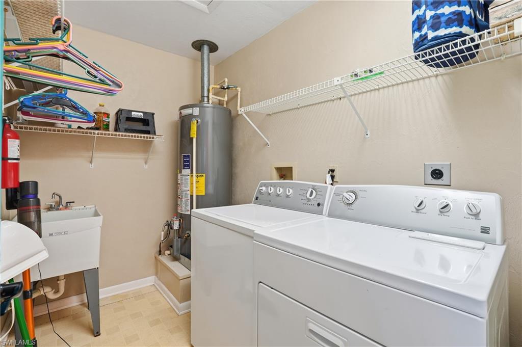 Laundry room with gas water heater, washer and dryer, and light flooring - Virtually Edited Image