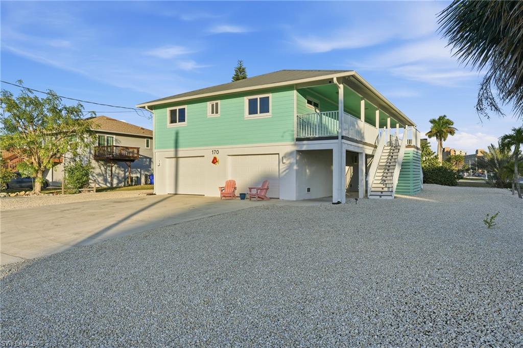 View of front of home with driveway, stairs, and a garage - Virtually Edited Image