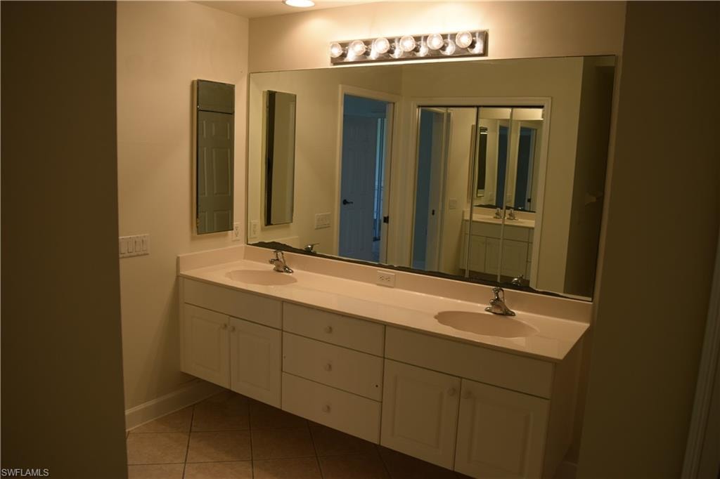 Bathroom featuring double vanity and light tile patterned floors