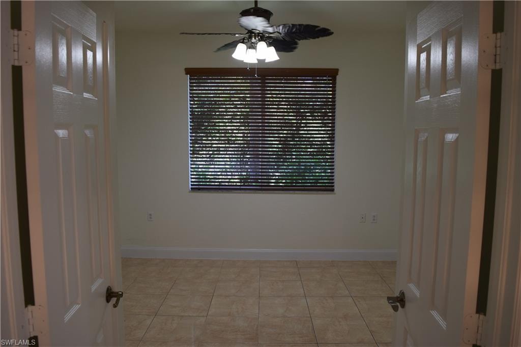 Unfurnished room with ceiling fan and light tile patterned floors