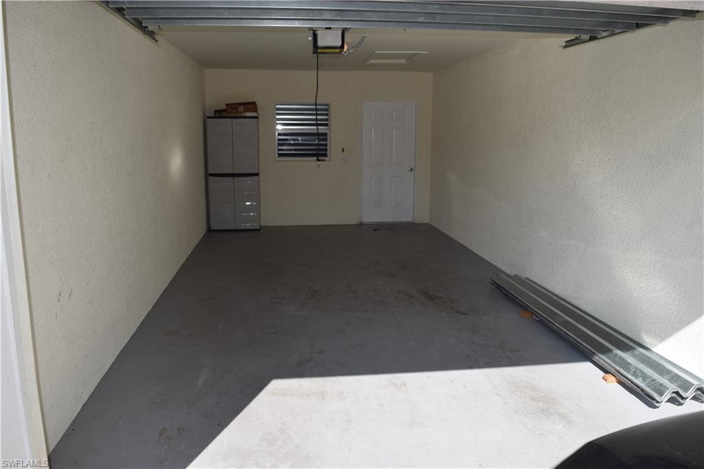 Garage with a textured wall and a garage door opener