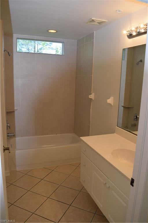Bathroom featuring vanity, washtub / shower combination, and light tile patterned flooring