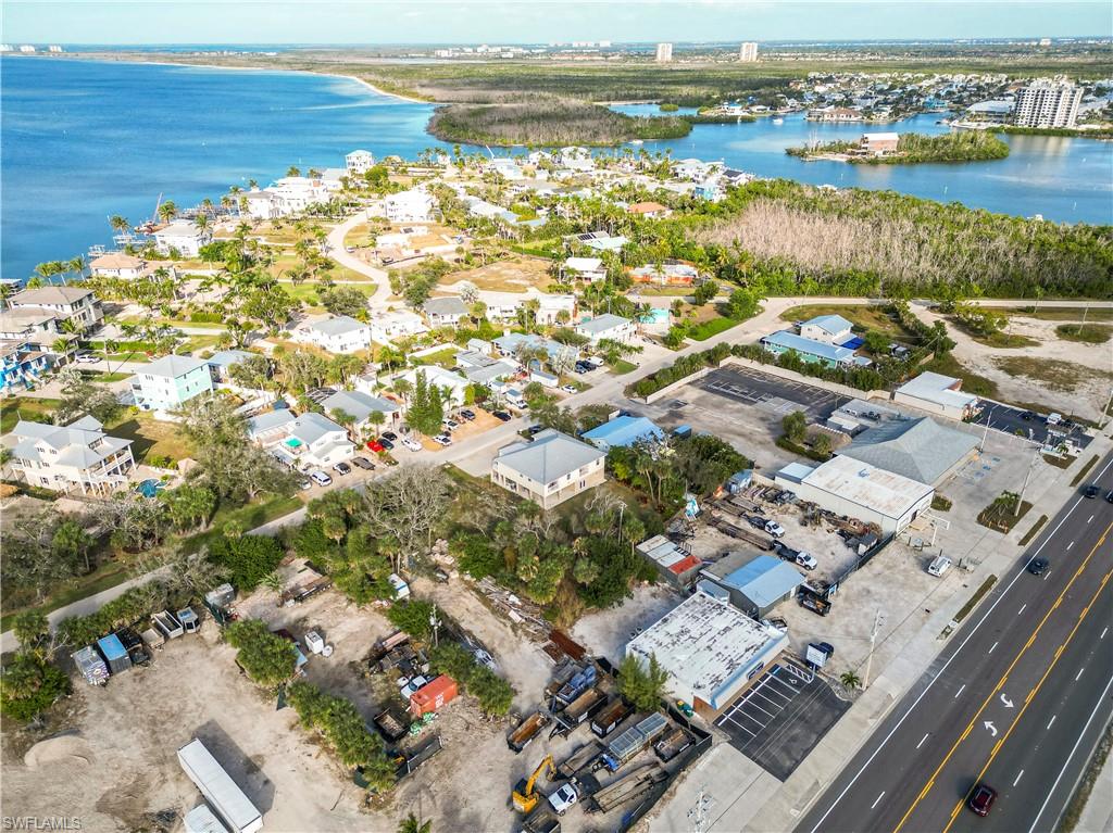 Aerial view of property and surrounding area with a nearby body of water
