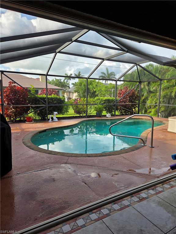 Swimming pool featuring a screened room and a patio area