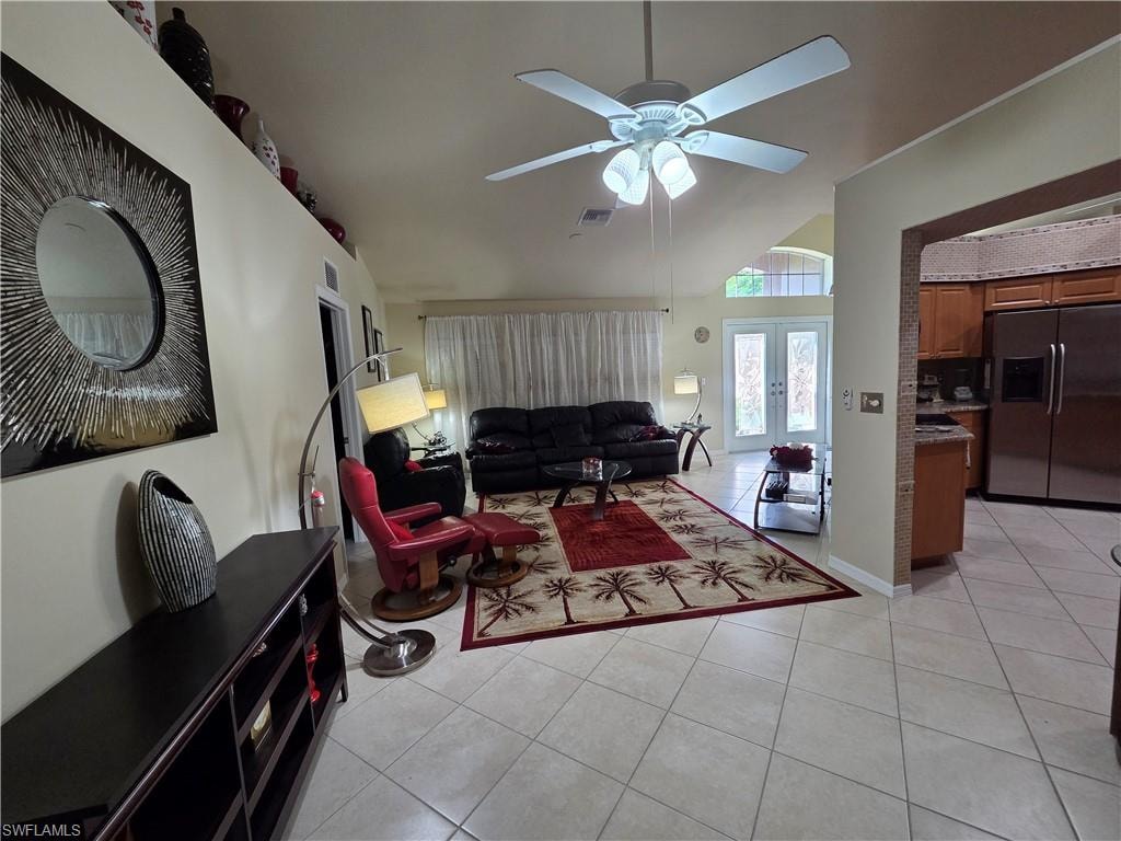 Living room with light tile flooring, a ceiling fan, lofted ceiling