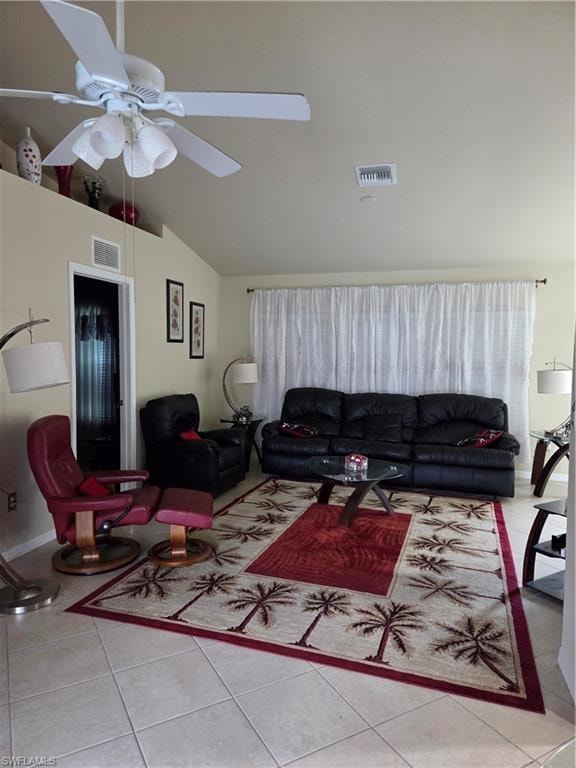 Living area with light tile floors, vaulted ceiling, and a ceiling fan