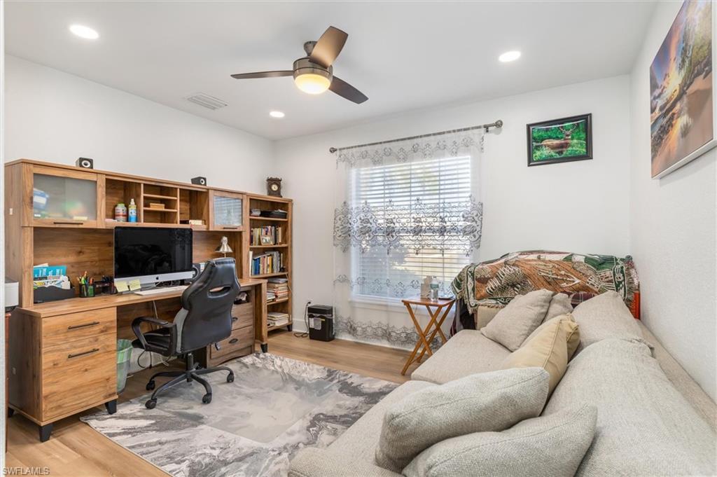 Home office with light wood-type flooring, a ceiling fan, and recessed lighting