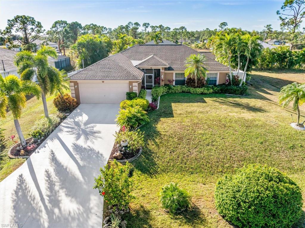 Single story home featuring concrete driveway, stucco siding, a front lawn, and a garage