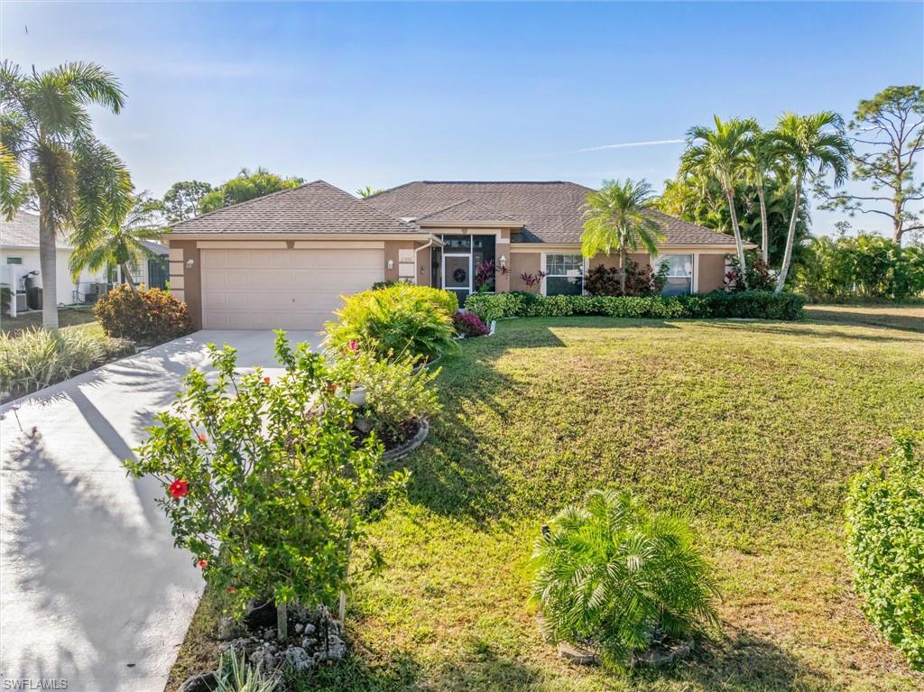 Single story home with a front yard, concrete driveway, stucco siding, and a garage