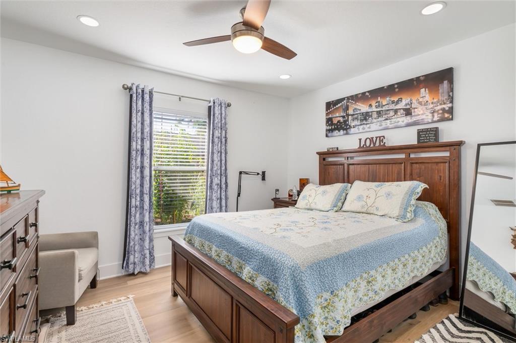 Bedroom with light wood-style floors, a ceiling fan, and recessed lighting