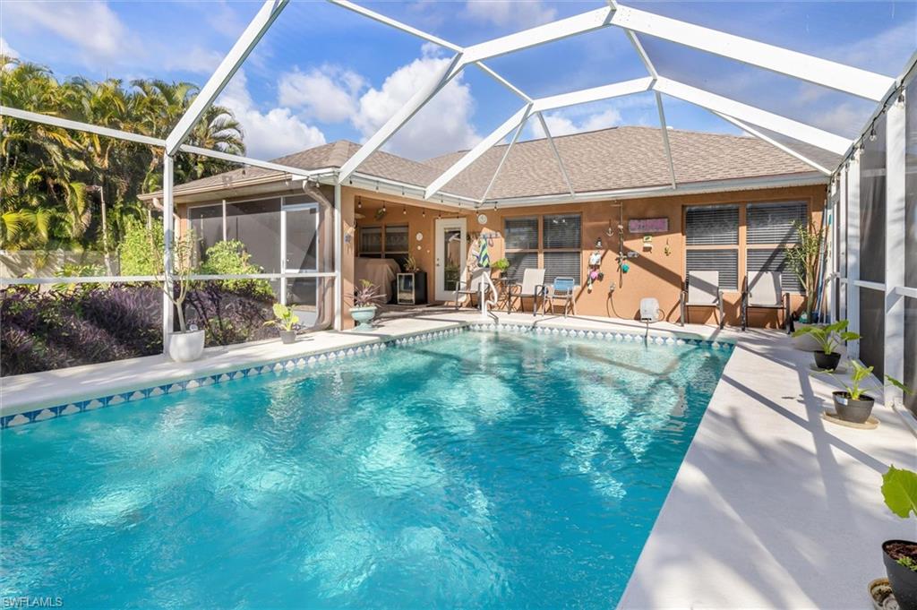 Swimming pool with glass enclosure, a sunroom, and a patio area