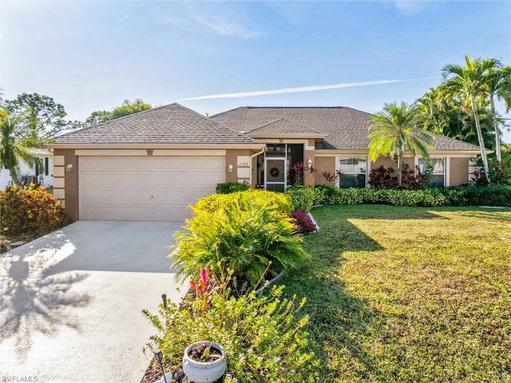 Single story home featuring driveway, stucco siding, a front yard, and a garage