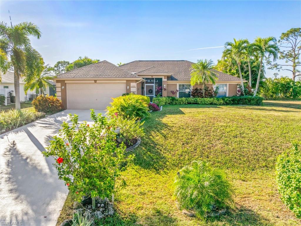 Ranch-style house featuring driveway, stucco siding, a front yard, and a garage