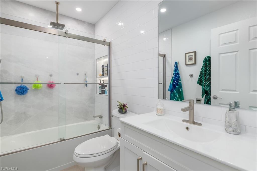 Bathroom with vanity and a combined bath / shower with rainfall shower
