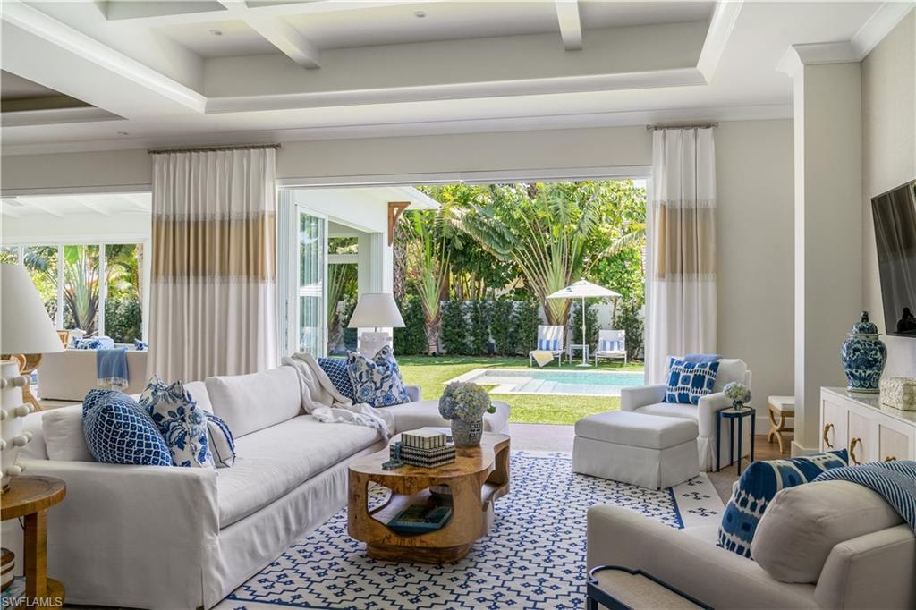 Living room featuring healthy amount of natural light, beam ceiling, and coffered ceiling