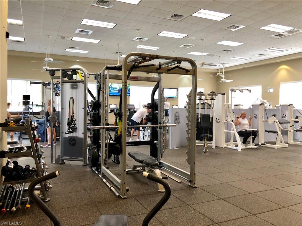 Gym featuring a ceiling fan and a drop ceiling