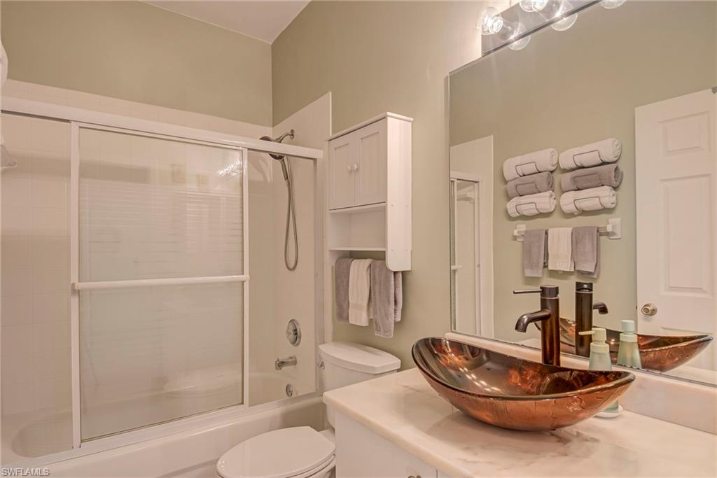 Full bathroom with vanity and enclosed tub / shower combo