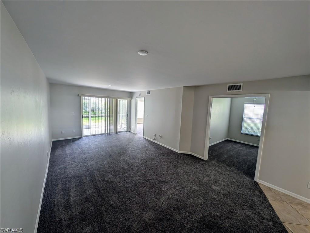 Open living room with healthy amount of natural light and light carpet