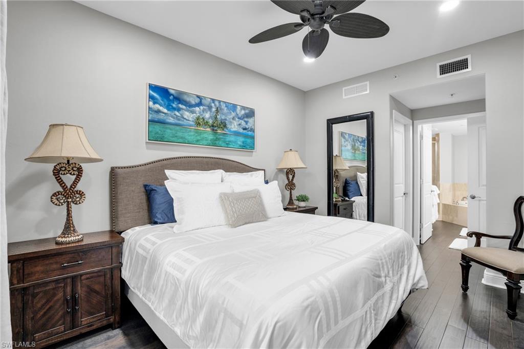 Bedroom with dark wood-type flooring, a ceiling fan, and ensuite bathroom