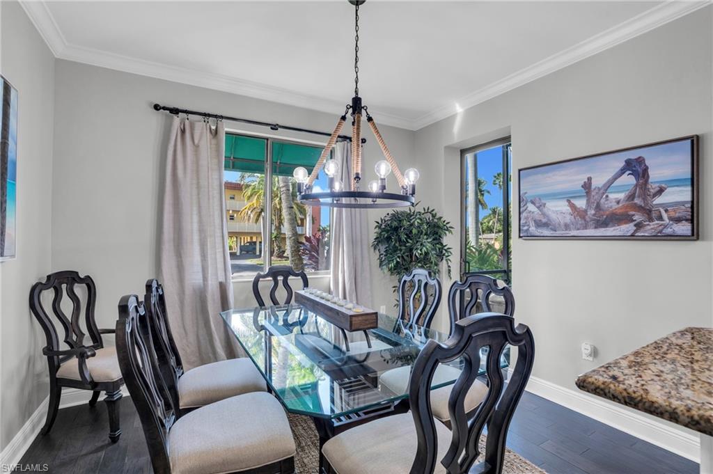 Dining room featuring a chandelier, wood finished floors, and crown molding