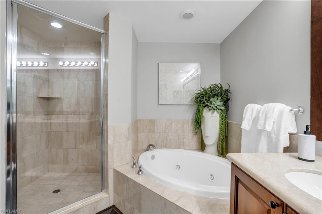 Bathroom with a whirlpool tub, vanity, and a shower stall