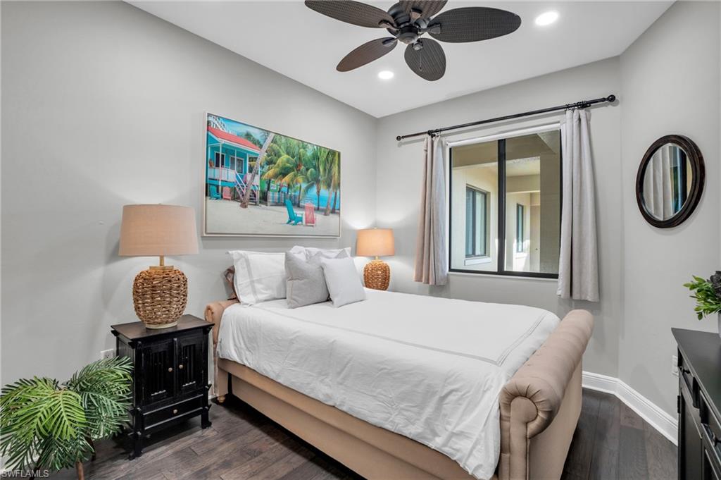 Bedroom with dark wood-style floors, ceiling fan, and recessed lighting