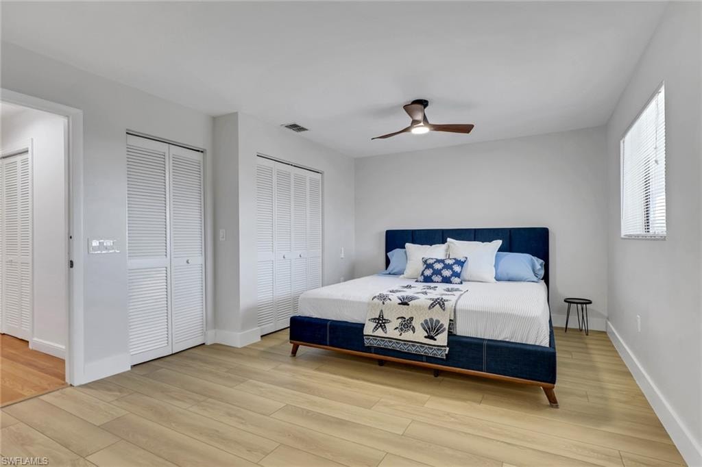 Bedroom 2 with multiple closets, light wood-type flooring, and ceiling fan