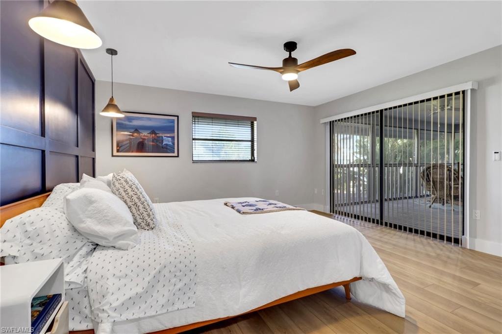 Bedroom 1- with access to outside, wood finished floors, and a ceiling fan