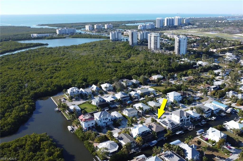 Aerial view of property and surrounding area featuring a large body of water and nearby urban area