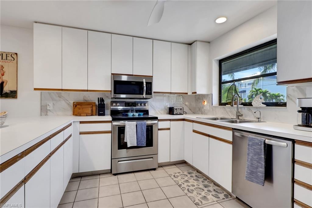 Kitchen featuring white cabinetry, appliances with stainless steel finishes, light countertops, backsplash, and recessed lighting